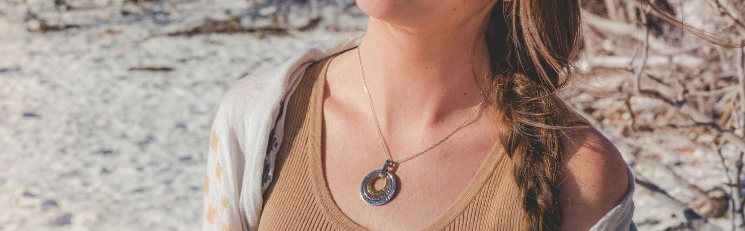 Hand stamped necklace with children's names on a model