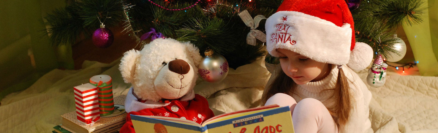 Little girl under Christmas Tree with Teddy Bear