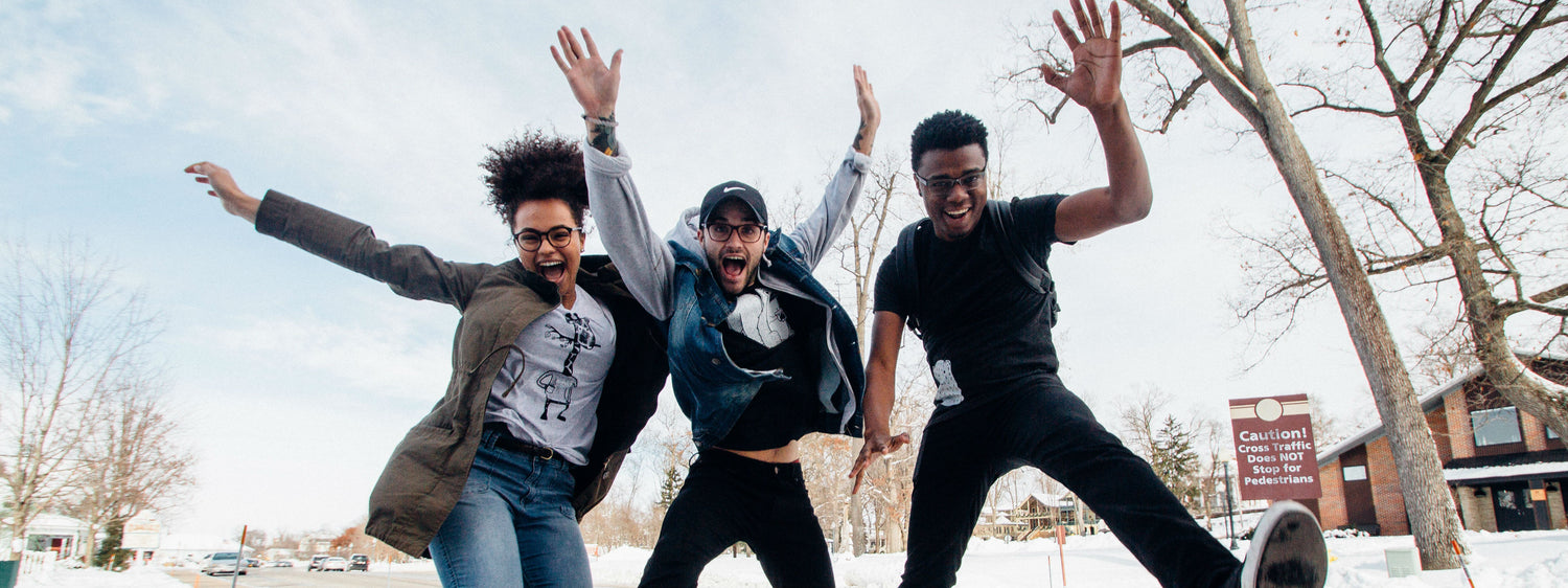 Three people jumping in the air to celebrate